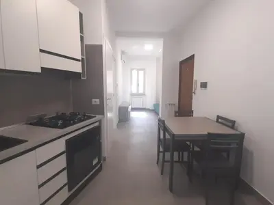 a kitchen with a stove and a table with chairs at Pigneto Giardino e Posto Auto Privati in Rome