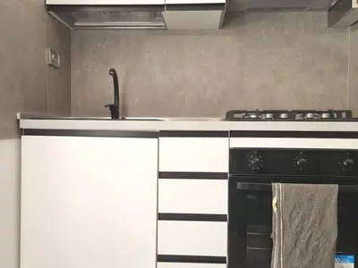 a kitchen with a black and white stove top oven at Pigneto Giardino e Posto Auto Privati in Rome