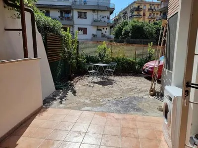 a patio with a table in a courtyard with a building at Pigneto Giardino e Posto Auto Privati in Rome