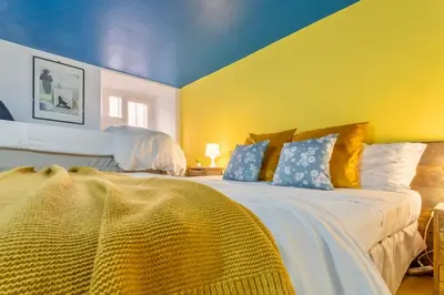 a bedroom with two beds with yellow walls and blue ceilings at Rossana Urban Style Loft close to Termini Station in Rome