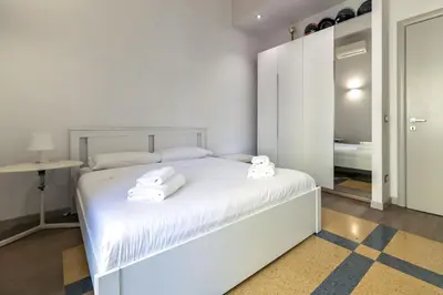a white bedroom with a bed with towels on it at Villa Ada Apartment - Parioli in Rome