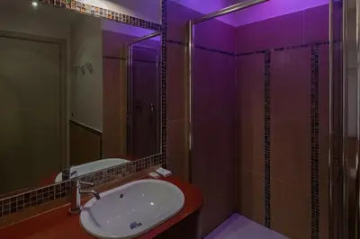 a bathroom with a sink and a shower with purple lighting at Villa Ada Apartment - Parioli in Rome
