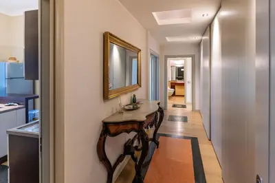 a hallway with a table and a mirror on a wall at Villa Ada Apartment - Parioli in Rome