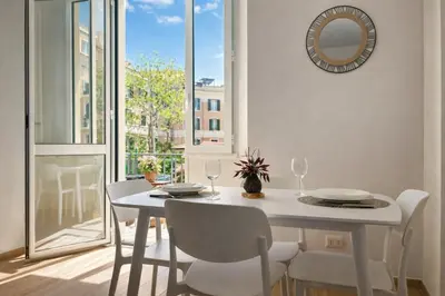 a white dining room with a white table and chairs at MariElu a Trastevere in Rome