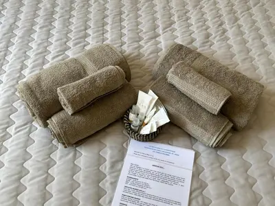 two towels on a bed with a piece of paper at MariElu a Trastevere in Rome