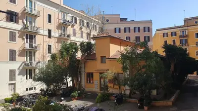 a group of buildings with palm trees in front of them at MariElu a Trastevere in Rome