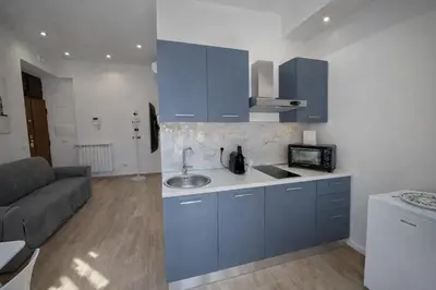 a kitchen with blue cabinets and a sink and a couch at MariElu a Trastevere in Rome