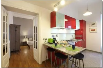 a kitchen with red cabinets and a island with bar stools at Saint Bon Apartment Good for Families in Rome