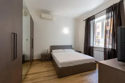 a bedroom with a bed and a large window at Casa Voghera in Rome