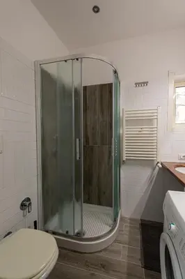 a glass shower in a bathroom with a toilet at Casa Voghera in Rome