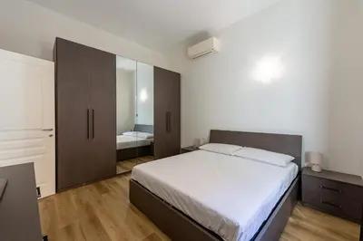 a bedroom with a large bed and a mirror at Casa Voghera in Rome