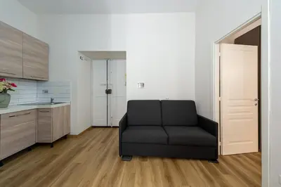 a living room with a black couch in a kitchen at Casa Voghera in Rome