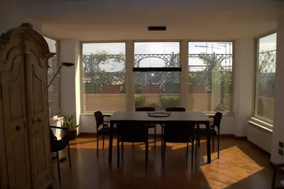 a dining room with a table and chairs and windows at La Dolce Vista in Rome