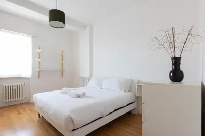a white bedroom with a bed with a stuffed animal on it at Agostini 9- Bright Flat in Rome