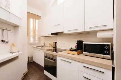 a kitchen with white cabinets and a microwave at Santamato Vatican Apartment in Rome