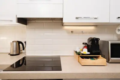 a kitchen with white cabinets and a counter top at Santamato Vatican Apartment in Rome