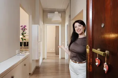 a woman standing in an open door in a room at Santamato Vatican Apartment in Rome