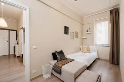 a bedroom with a bed and a couch and a window at Santamato Vatican Apartment in Rome