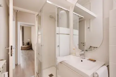 a white bathroom with a sink and a mirror at Santamato Vatican Apartment in Rome