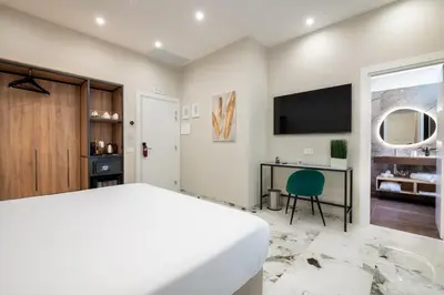 a bedroom with a large bed and a desk at 69 Suite Boutique in Rome