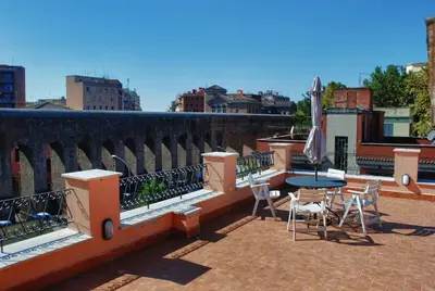 a patio with a table and chairs on a balcony at Villa Lanusei in Rome