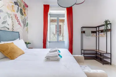 a bedroom with a white bed with towels on it at iFlat Monti Brand New Spacious & Comfortable Gem in Rome