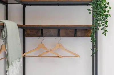 a wooden shelf with hangers and a plant at iFlat Monti Brand New Spacious & Comfortable Gem in Rome