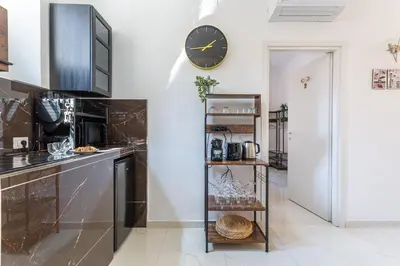 a kitchen with a clock on the wall and a shelf at iFlat Monti Brand New Spacious & Comfortable Gem in Rome