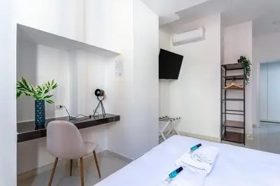 a white room with a bed and a chair at iFlat Monti Brand New Spacious & Comfortable Gem in Rome