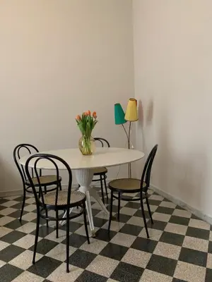 a table with chairs and a vase of flowers on it at Santa Monica in Rome