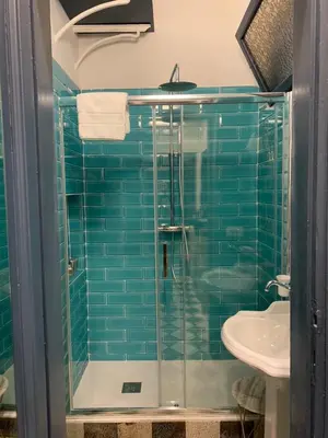 a bathroom with a glass shower and a sink at Santa Monica in Rome