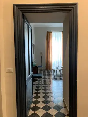 a hallway with a door to a room with a checkered floor at Santa Monica in Rome