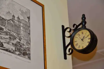a clock hanging on a wall next to a picture at Trastevere elegant apartment in Rome