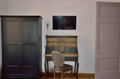 a desk with a chair and a tv on a wall at Trastevere elegant apartment in Rome