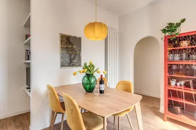 a dining room with a wooden table and a vase with flowers at Attic with terrace Spanish Steps exclusive in Rome