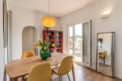 a dining room table with chairs and a vase of flowers at Attic with terrace Spanish Steps exclusive in Rome