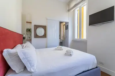 a bedroom with a large white bed with a red headboard at iFlat Contemporary Design Living in Rome in Rome