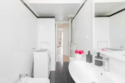 a white bathroom with a toilet and a sink at Caracciolo Vatican Apartment in Rome