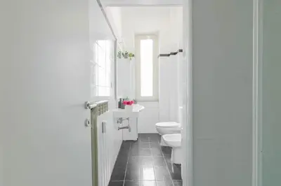 a white bathroom with a toilet and a sink at Caracciolo Vatican Apartment in Rome