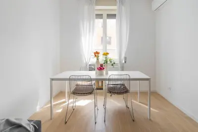 a white table with two chairs in a white room at Caracciolo Vatican Apartment in Rome