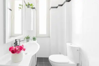 a white bathroom with a toilet and a sink at Caracciolo Vatican Apartment in Rome