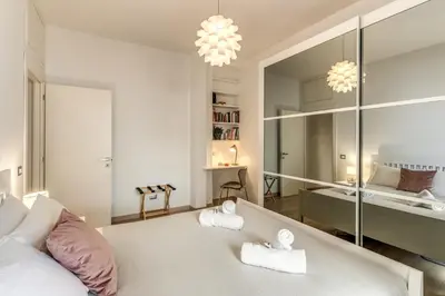 a bedroom with a large white bed with two towels at Santa Croce apartment with private terrace in Rome