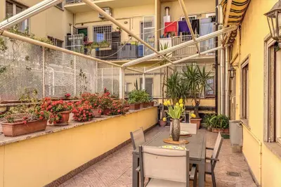 a balcony with tables and chairs and potted plants at Santa Croce apartment with private terrace in Rome