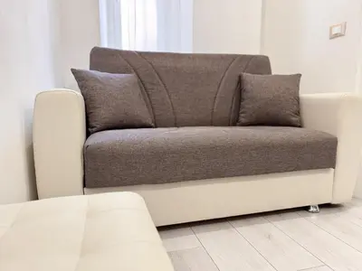a couch sitting in a living room next to a window at Valerias Nest Elegant Apt with WiFi and Charm in Rome