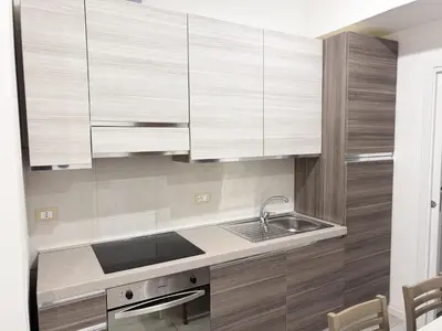 a kitchen with wooden cabinets and a sink at Valerias Nest Elegant Apt with WiFi and Charm in Rome