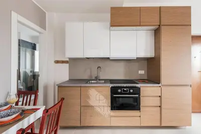 a kitchen with white cabinets and a sink and a stove at Prestige Bellavista Apartment in Rome