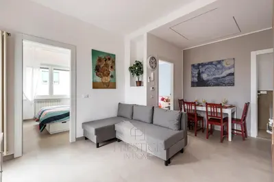 a living room with a couch and a dining room at Prestige Bellavista Apartment in Rome