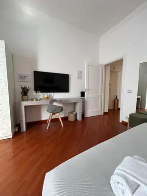 a white room with a desk and a tv at Domus Vittoria in Rome
