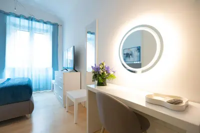 a bedroom with a white bed with a blue pillow at Vatican Best Suite in Rome