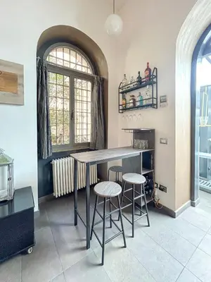 a kitchen with a table and two stools at Domus Loft Colosseum - Rione Monti in Rome